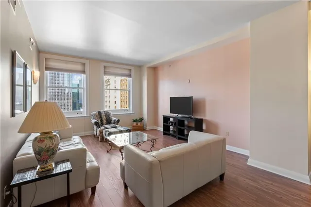 a living room with furniture wooden floor and a flat screen tv