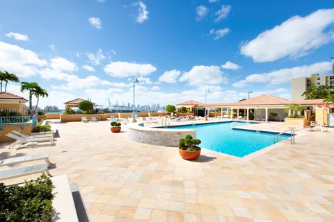 a view of a swimming pool with a patio and a yard