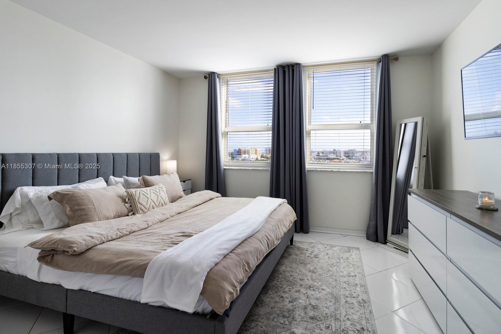 90 Alton Road, Unit 1005 Miami Beach, FL 33139 - Photo 10 of 22 a bedroom with a large bed and a window