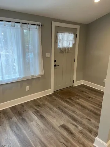 a view of a room with wooden floor and a window