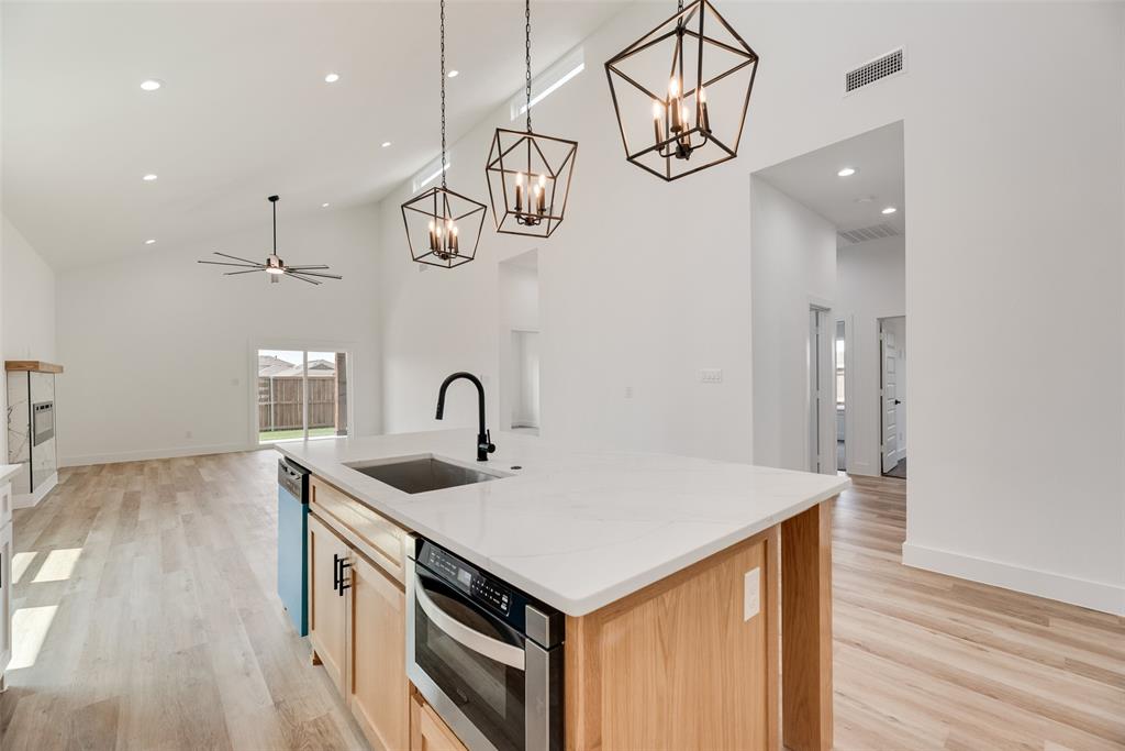 110 Hesed Street Greenville, TX 75402 - Photo 12 of 33 a kitchen that has a lot of cabinets and wooden floor
