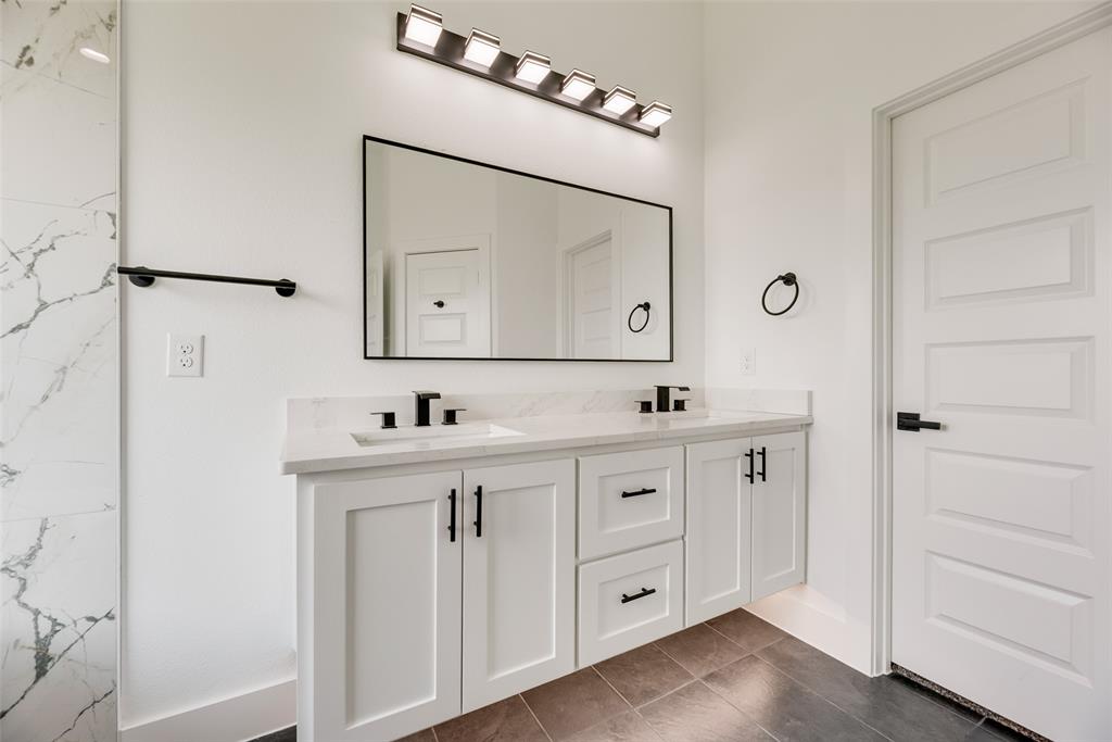 110 Hesed Street Greenville, TX 75402 - Photo 18 of 33 a spacious bathroom with a double vanity sink a mirror and shower