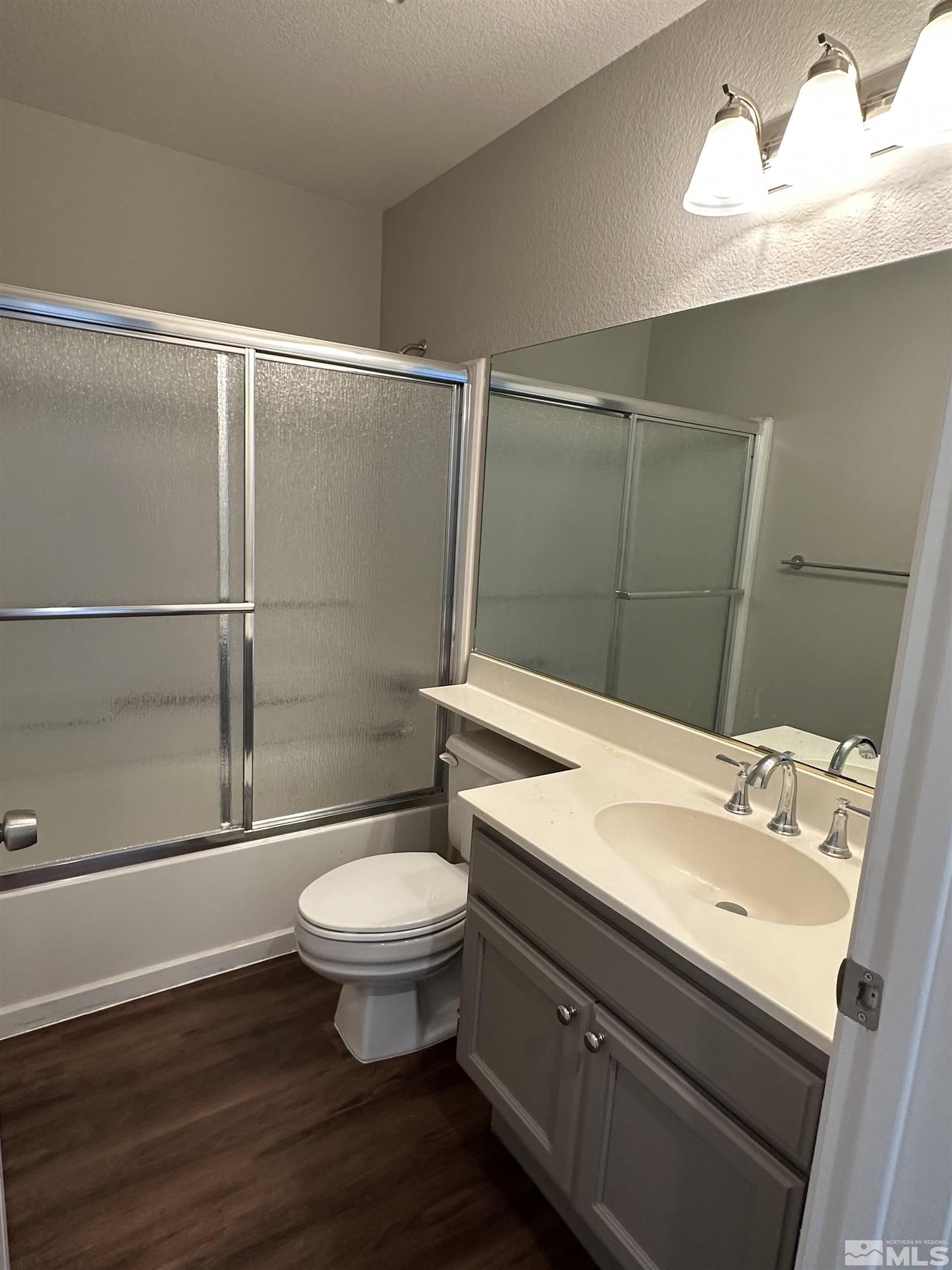 7485 Wheeldale Circle Reno, NV 89511 - Photo 10 of 12 a bathroom with a sink a toilet a mirror and shower