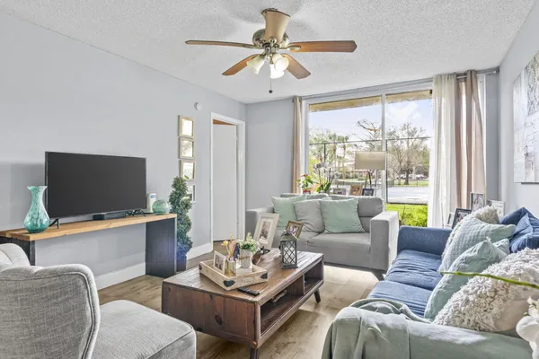 a living room with furniture a large window and a flat screen tv