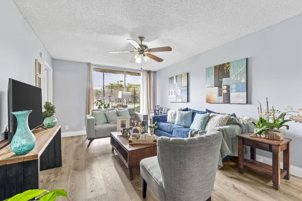 a living room with furniture a chandelier and a potted plant
