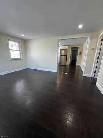 an empty room with wooden floor and cabinet