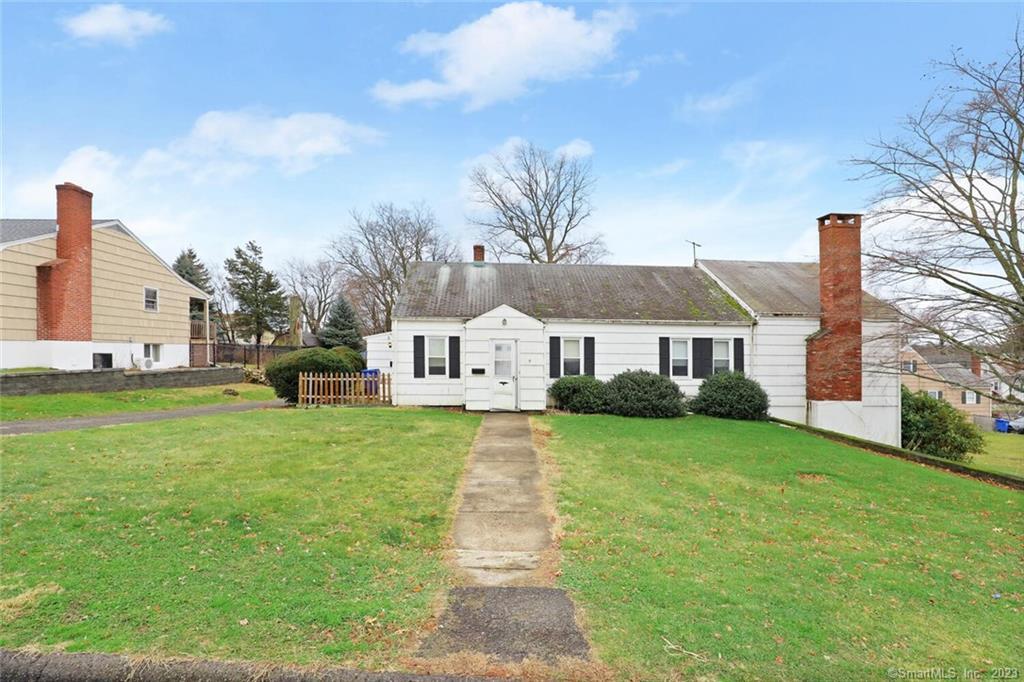 a front view of a house with a garden and yard