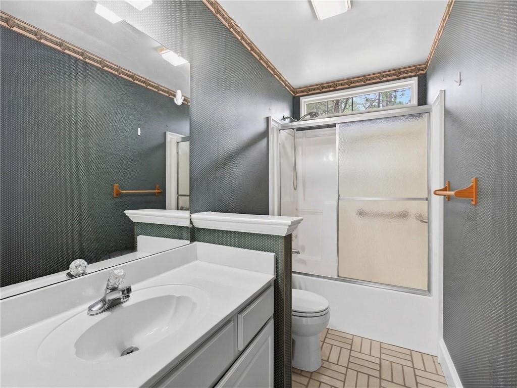 2038 Buford Dam Road Buford, GA 30518 - Photo 21 of 56 a bathroom with a sink a toilet and shower