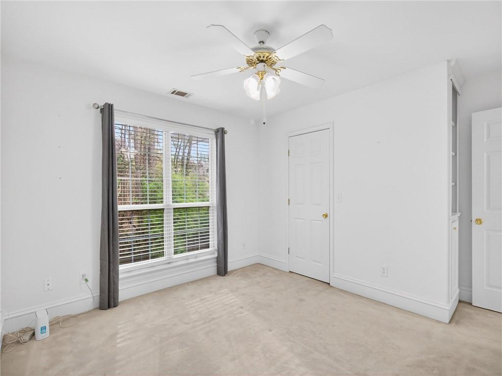 2038 Buford Dam Road Buford, GA 30518 - Photo 22 of 56 an empty room with windows and fan