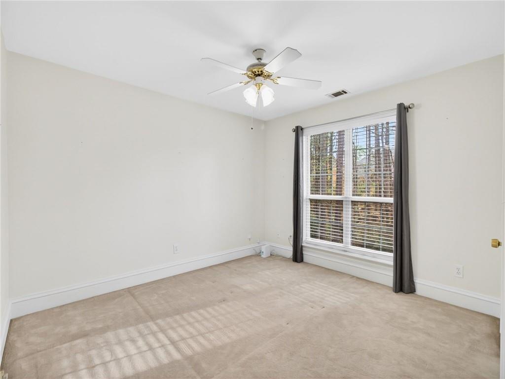 2038 Buford Dam Road Buford, GA 30518 - Photo 23 of 56 an empty room with fan and windows