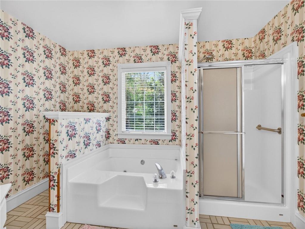 2038 Buford Dam Road Buford, GA 30518 - Photo 35 of 56 a bathroom with a bathtub and shower