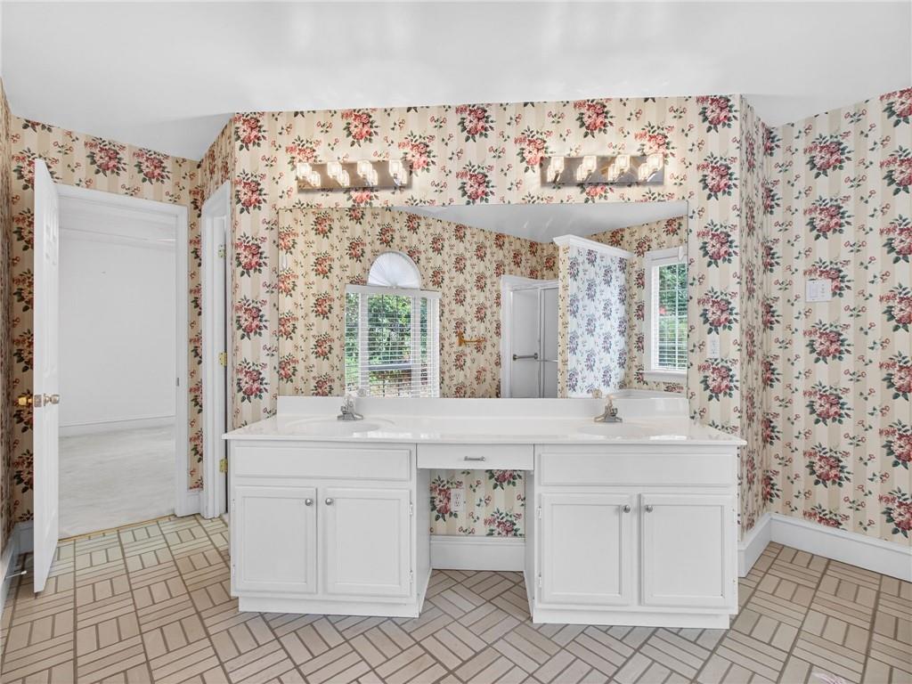 2038 Buford Dam Road Buford, GA 30518 - Photo 38 of 56 a bathroom with a sink a vanity and a mirror