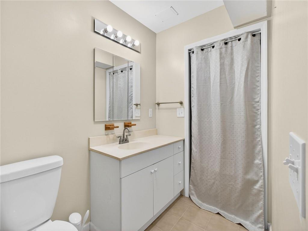 2038 Buford Dam Road Buford, GA 30518 - Photo 45 of 56 a bathroom with a toilet a sink and a mirror