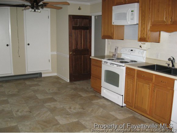 225 Cecil Avenue Spring Lake, NC 28390 - Photo 15 of 24 a kitchen with cabinets appliances and a wooden floor