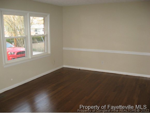 225 Cecil Avenue Spring Lake, NC 28390 - Photo 3 of 24 an empty room with wooden floor and windows