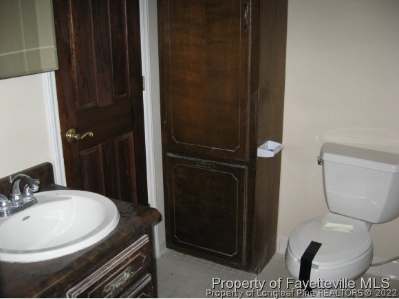 225 Cecil Avenue Spring Lake, NC 28390 - Photo 6 of 24 a bathroom with a toilet a sink and mirror