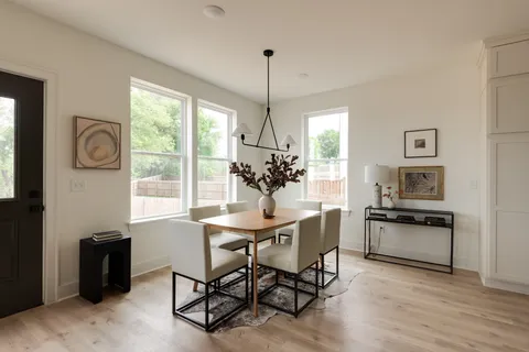 a living room with furniture or couches and a dining table with wooden floor