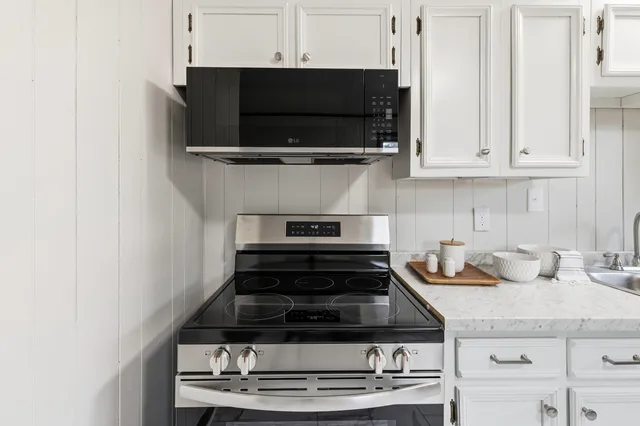a kitchen with stainless steel appliances granite countertop a stove and a microwave