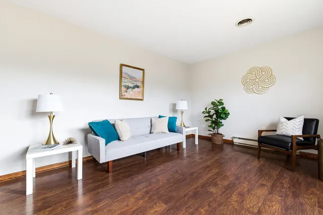 a living room with furniture and wooden floor