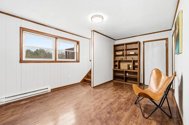 a view of an empty room with furniture and a window