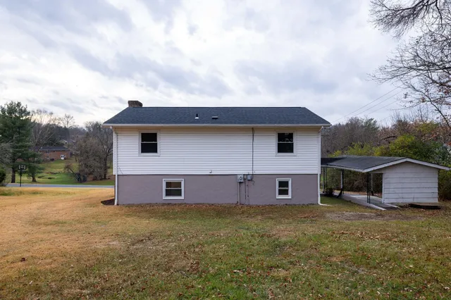 a view of a house with backyard and brick wall