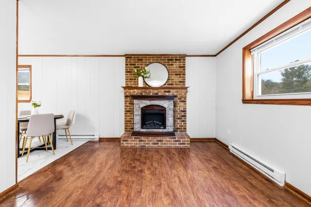 a view of a livingroom with a fireplace and window