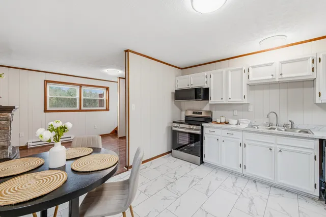 a kitchen with stainless steel appliances kitchen island granite countertop a sink and cabinets
