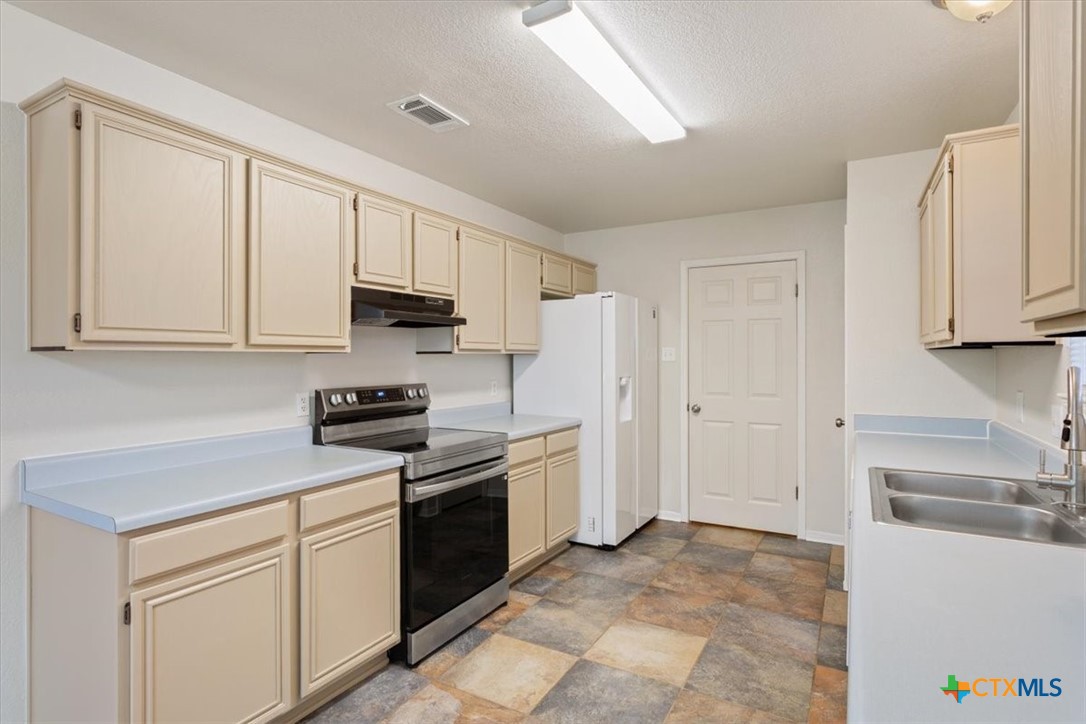 204 Rodeo Circle Copperas Cove, TX 76522 - Photo 11 of 28 a kitchen with white cabinets and stainless steel appliances