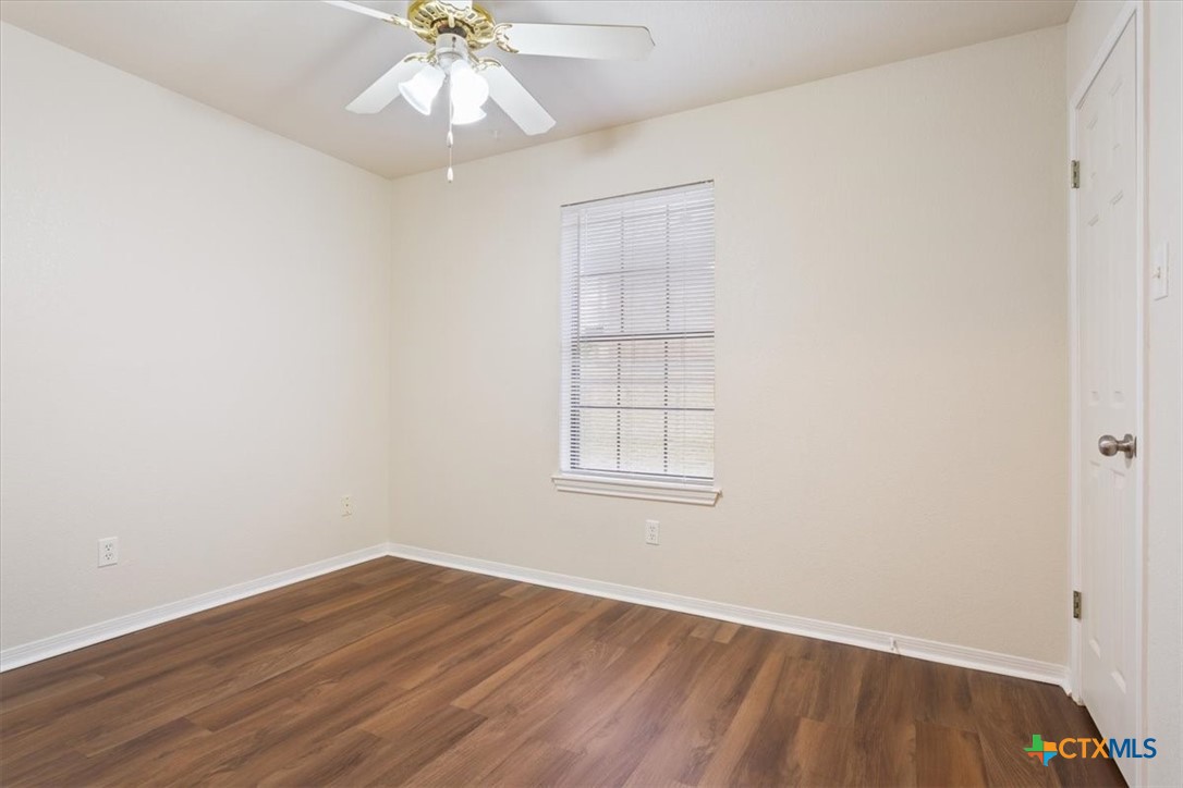 204 Rodeo Circle Copperas Cove, TX 76522 - Photo 21 of 28 an empty room with wooden floor chandelier fan and windows
