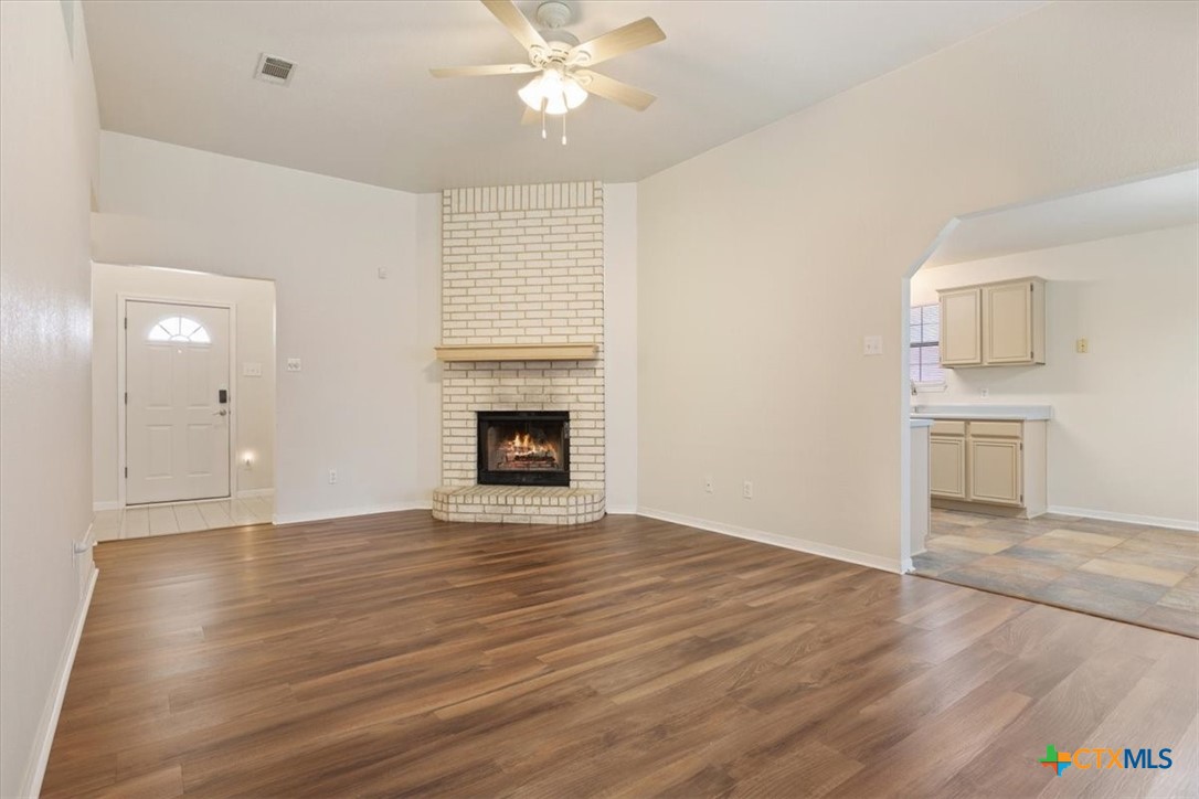 204 Rodeo Circle Copperas Cove, TX 76522 - Photo 7 of 28 an empty room with wooden floor fireplace and windows