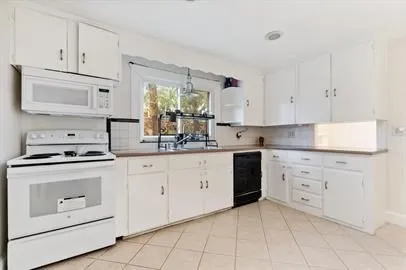 a kitchen with cabinets appliances a sink and a window
