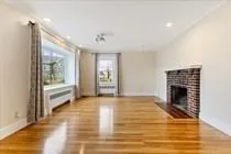 a view of an empty room with a fireplace and a window