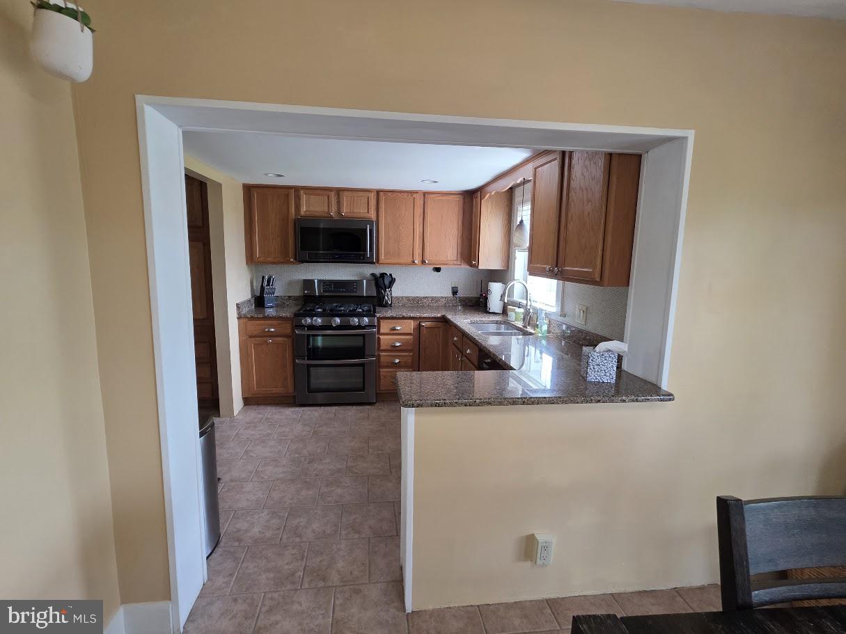 4903 Erie Road Harrisburg, PA 17111 - Photo 11 of 33 a kitchen with stainless steel appliances granite countertop a stove top oven a sink and a microwave