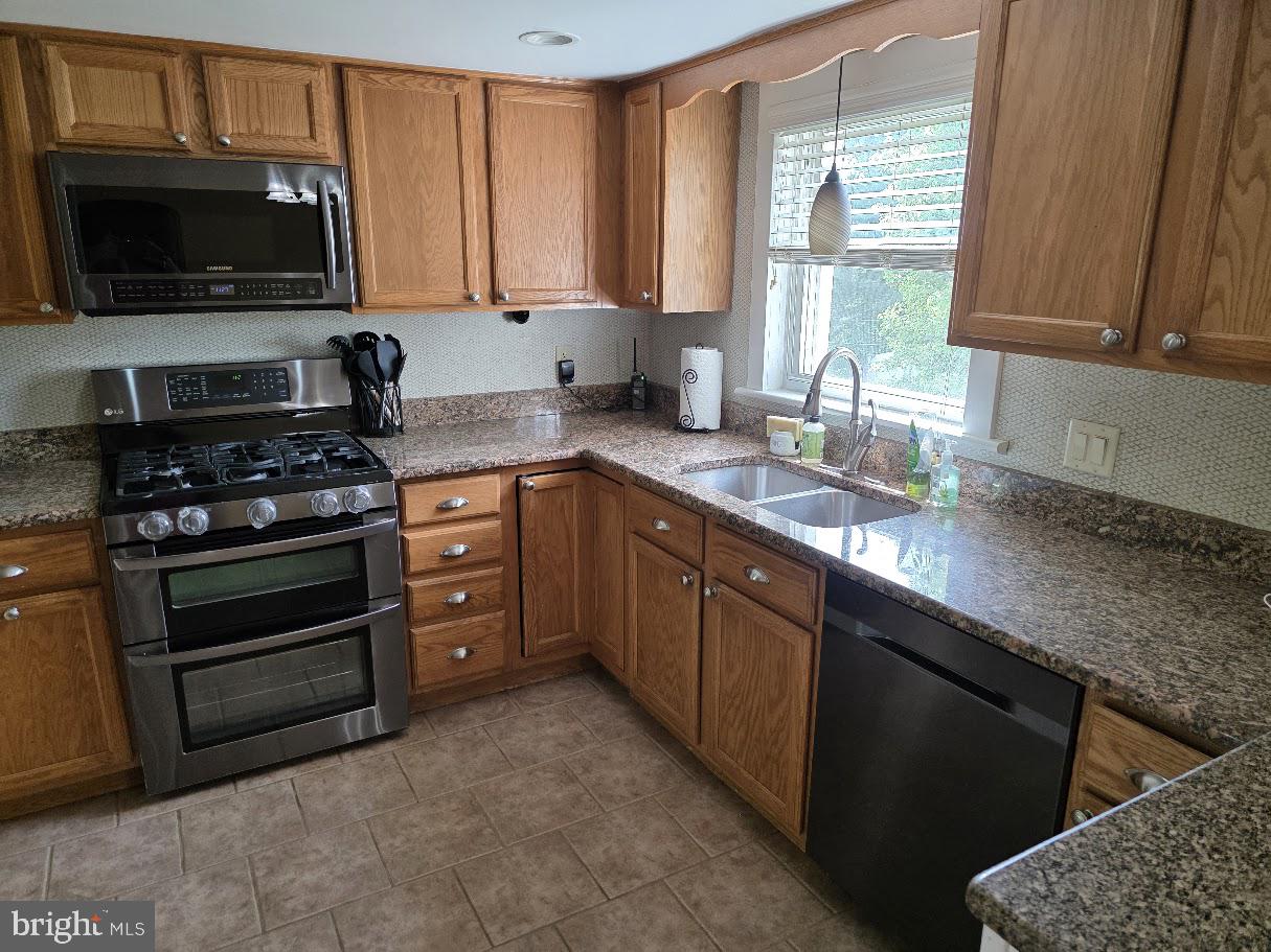 4903 Erie Road Harrisburg, PA 17111 - Photo 13 of 33 a kitchen with stainless steel appliances a stove sink and microwave