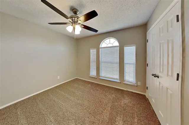 an empty room with fan and windows