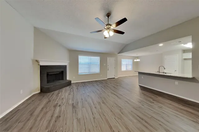 a view of a livingroom with a fireplace and wooden floor
