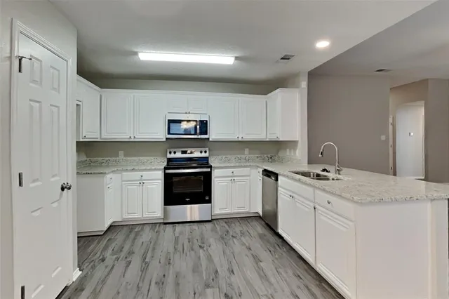 a kitchen with granite countertop white cabinets and white appliances