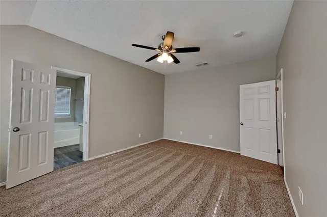a view of a room with a ceiling fan and hardwood floor