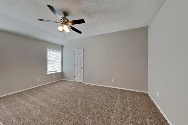a view of an empty room with a ceiling fan