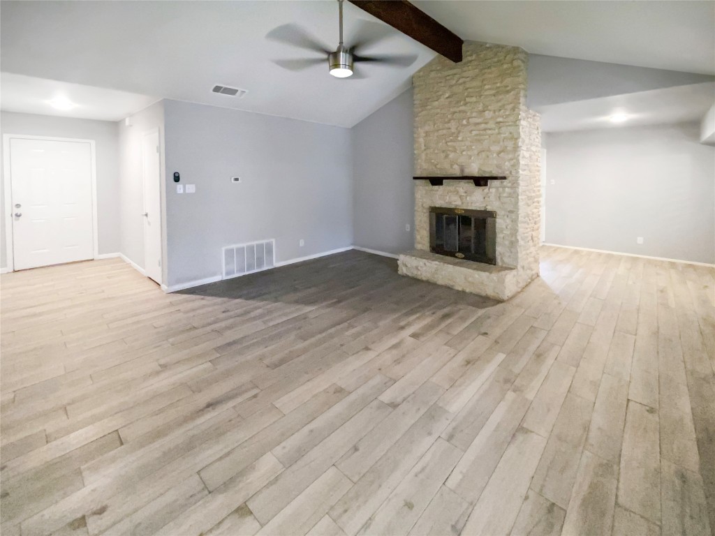 1503 Roundup Trail Round Rock, TX 78681 - Photo 6 of 23 Unfurnished living room featuring a fireplace, ceiling fan, and light wood-style flooring