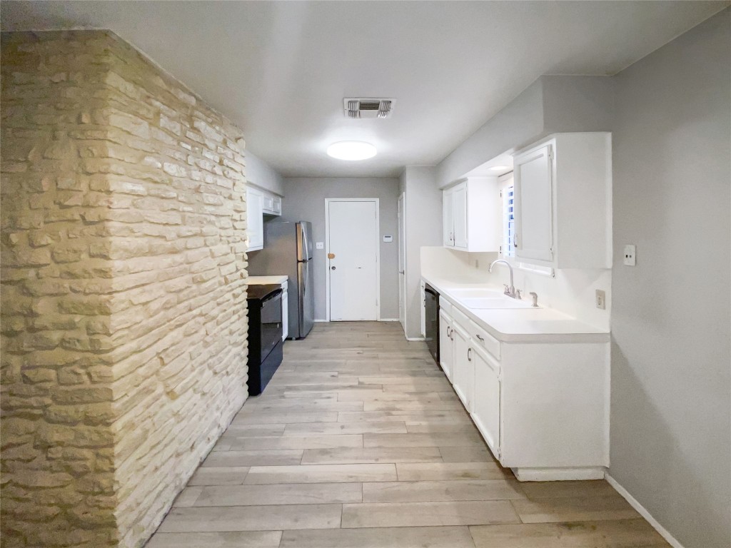 1503 Roundup Trail Round Rock, TX 78681 - Photo 7 of 23 Kitchen featuring white cabinets, light countertops, and light wood finished floors