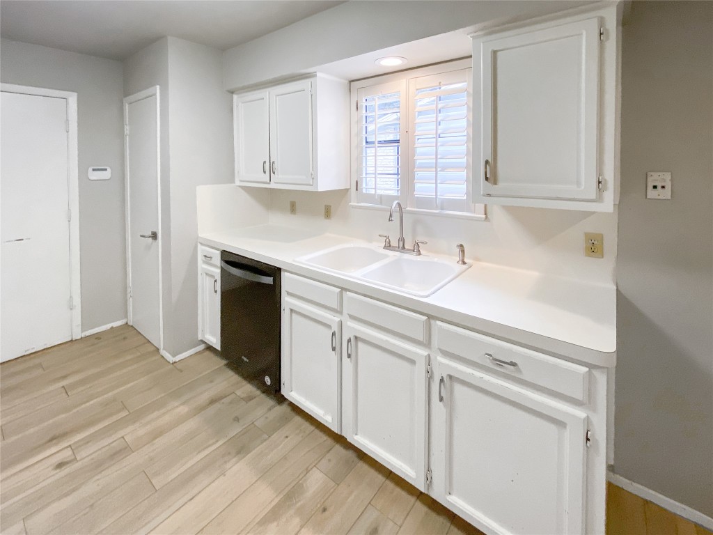 1503 Roundup Trail Round Rock, TX 78681 - Photo 8 of 23 Kitchen featuring white cabinetry, light countertops, dishwasher, and light wood-type flooring