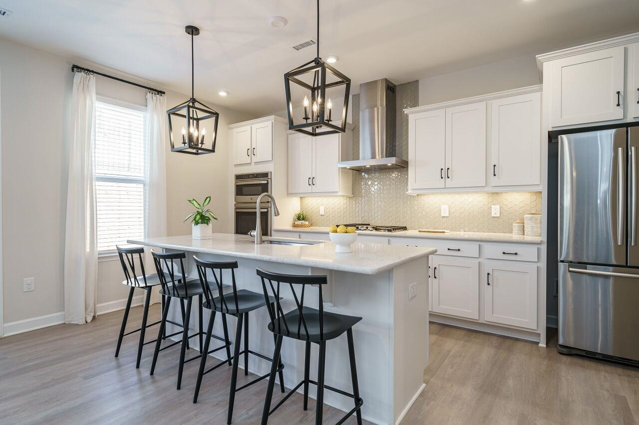 62 Maximus Circle Garner, NC 27529 - Photo 12 of 30 a kitchen with stainless steel appliances granite countertop a white refrigerator a sink a stove and white cabinets with wooden floor