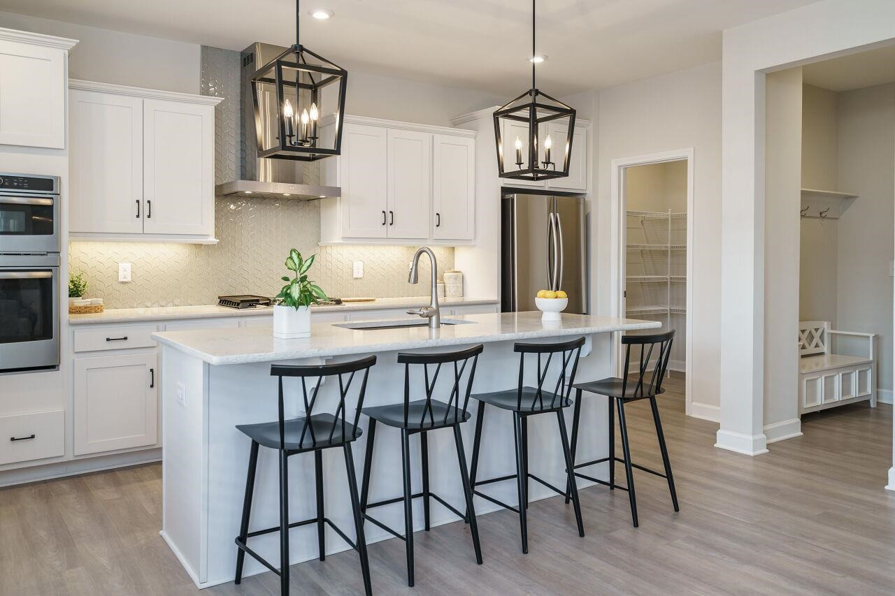 62 Maximus Circle Garner, NC 27529 - Photo 14 of 30 a kitchen with stainless steel appliances a dining table chairs refrigerator and microwave