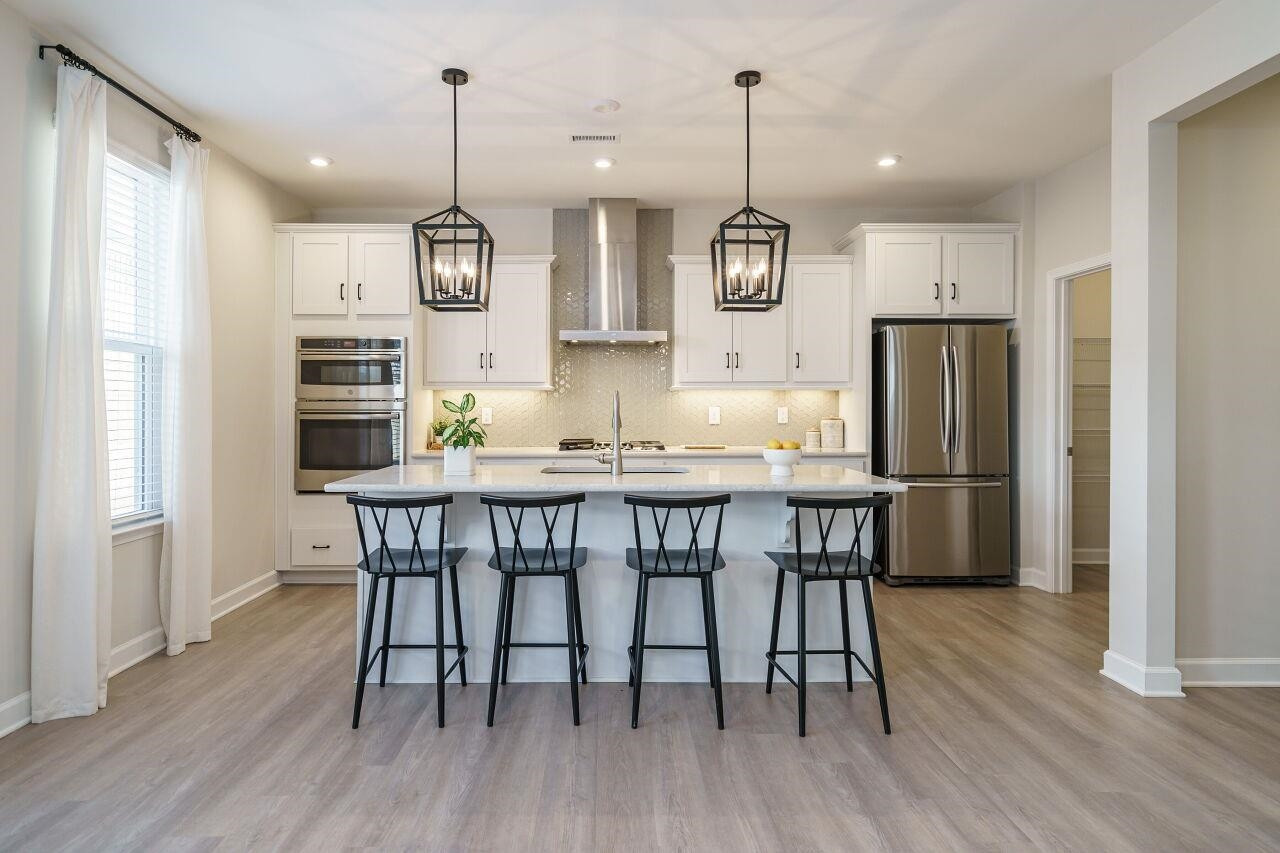 62 Maximus Circle Garner, NC 27529 - Photo 15 of 30 a kitchen with stainless steel appliances granite countertop wooden floor dining table and chairs