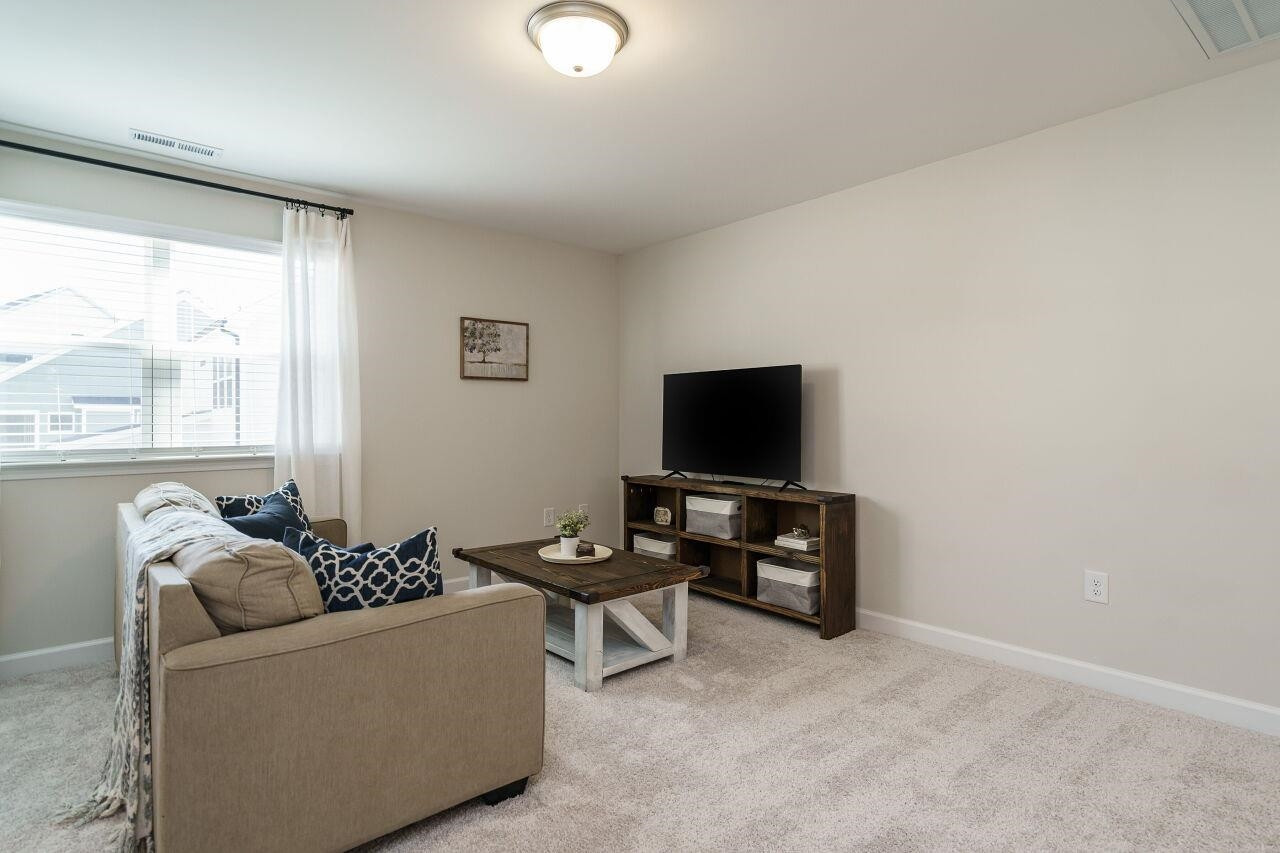 62 Maximus Circle Garner, NC 27529 - Photo 20 of 30 a living room with furniture and a flat screen tv