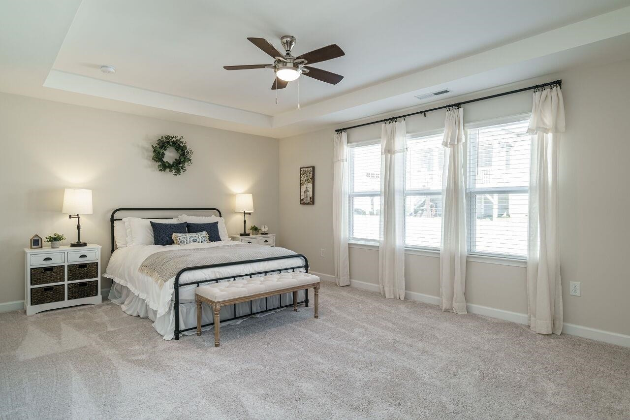 62 Maximus Circle Garner, NC 27529 - Photo 23 of 30 a spacious bedroom with a bed a chandelier and a large window