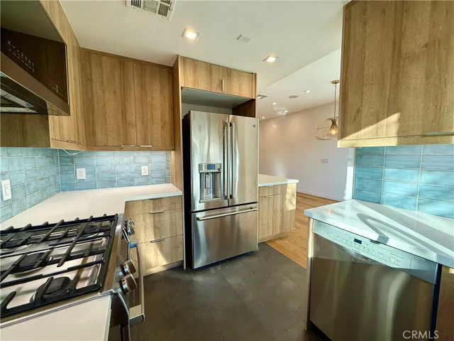 a kitchen with stainless steel appliances wooden cabinets sink and microwave