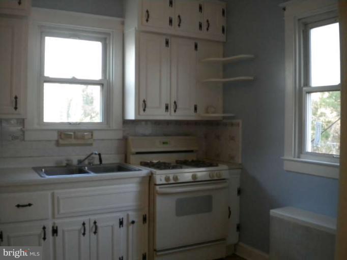 5527 Ashbourne Road Halethorpe, MD 21227 - Photo 7 of 30 a kitchen with granite countertop white cabinets appliances and a sink