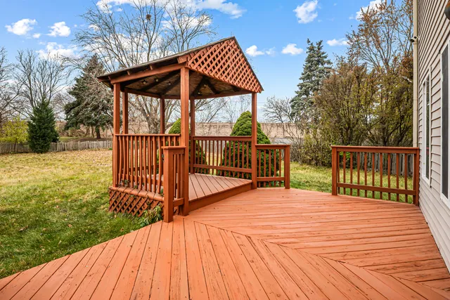 a view of backyard with small deck and wooden floor